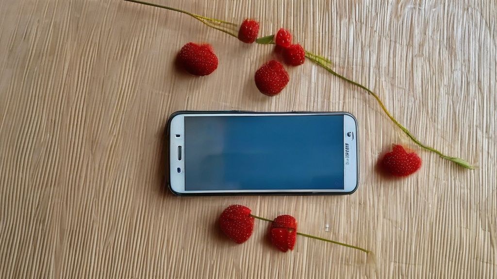 한국인 모델이 최신 스마트폰으로 야경을 촬영하는 모습, 스마트폰 화면에는 야간 모드 촬영 중임을 나타내는 아이콘 표시